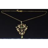Edwardian 15ct gold pendant set with two pear cut peridots and seed pearls, on a 15ct gold chain,