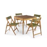 An Italian walnut poker table and four walnut and leather folding chairs designed by Gio Ponti for F