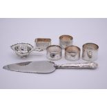 A small collection of silver items, to include; five napkin rings; and a tea strainer etc, 248g