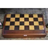 A Victorian mahogany and inlaid folding games board, 45.5cm wide; together with a mahogany cased set