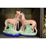 A pair of Victorian Staffordshire pottery greyhound and rabbit figure groups, 25cm high.