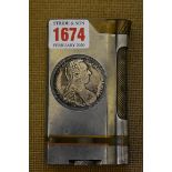 An unusual Trench Art style aluminium and brass table lighter, inset with two Maria Theresa coins,