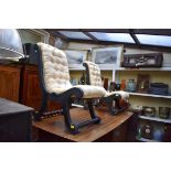 Two similar ebonized and button upholstered slipper back nursing chairs.