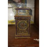 An antique brass champleve enamel carriage timepiece, height including handle 15cm, with winding