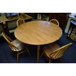 A blonde Ercol drop leaf table and four chairs, the table 112cm wide.