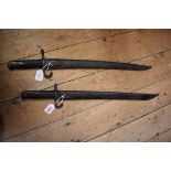 Two antique Yataghan sword bayonets and sheaths, each having 47cm blades.