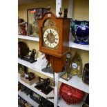 An oak hooded wall clock, by Gustav Becker, with pendulum, (lacking weights).