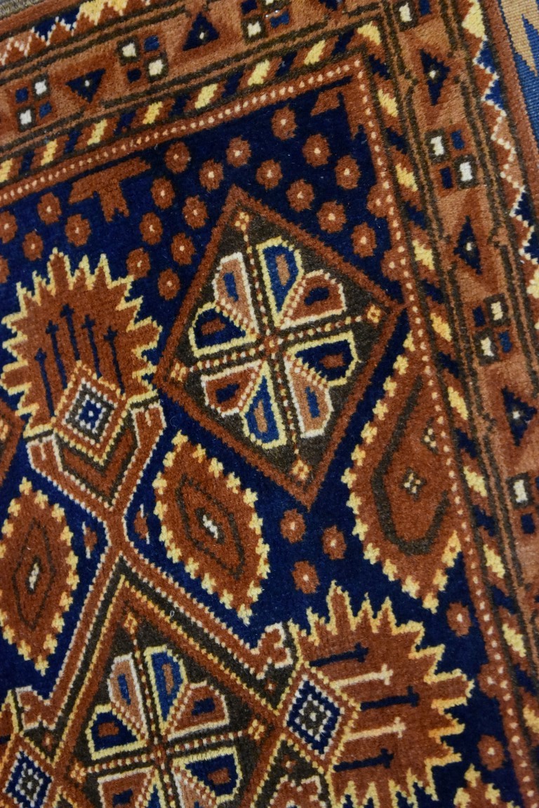 A small Persian rug, having floral decoration with hearts to central field on a blue and orange - Image 2 of 3