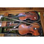 Two old violins; together with a distressed case and one bow.