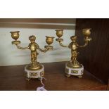 A pair of French gilt bronze and white marble faun twin branch candlesticks, inscribed to the
