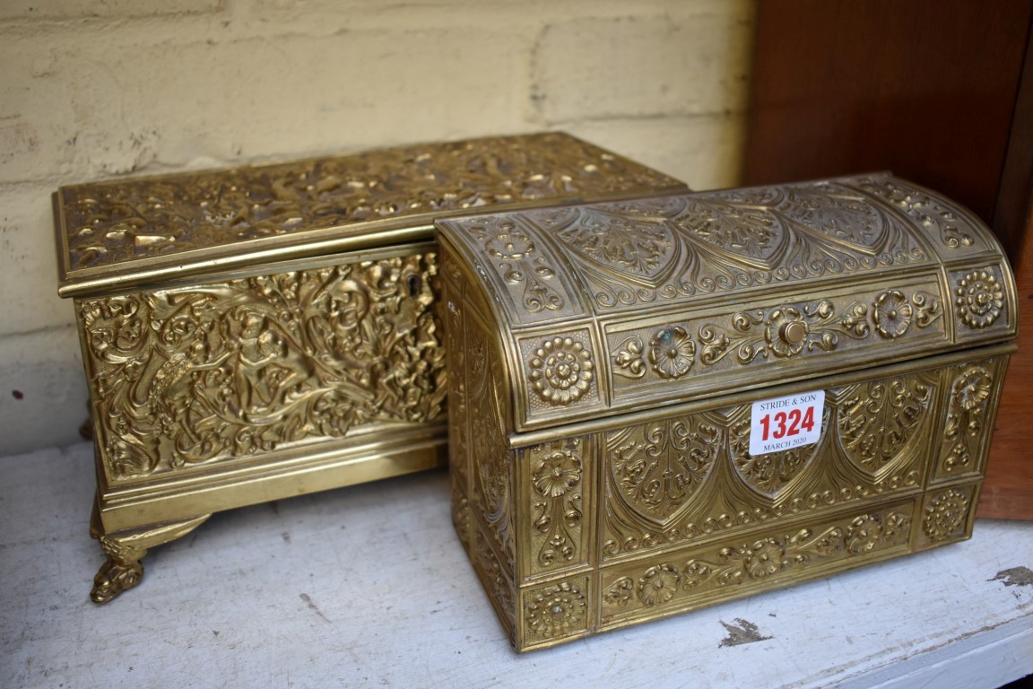 An embossed brass stationary casket, 21.5cm wide; together with another cast brass casket, 27.5cm