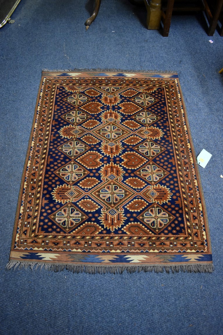 A small Persian rug, having floral decoration with hearts to central field on a blue and orange