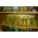 A collection of yellow uranium glass. (One shelf)