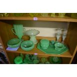 A collection of opaque green uranium glass. (One shelf)
