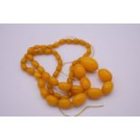 A graduated string of butterscotch amber beads, 66cm approximately, 47.2g