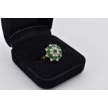 An emerald and diamond cluster gold ring, stamped 18ct, 5.2g total weight.