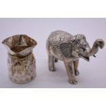 An Indian white metal elephant, 14cm high; together with a base metal sack vase.
