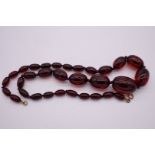 A graduated string of cherry amber beads, 57.5cm, 50.9g.