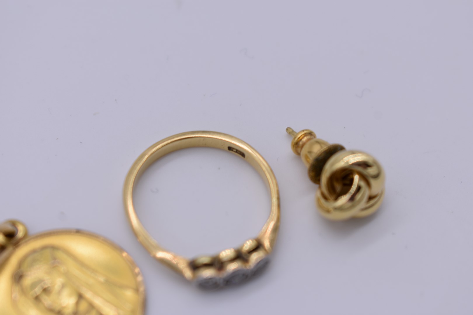 A triple diamond gold ring; together with a pair of gold knot ear studs; and a gold Madonna - Image 2 of 2