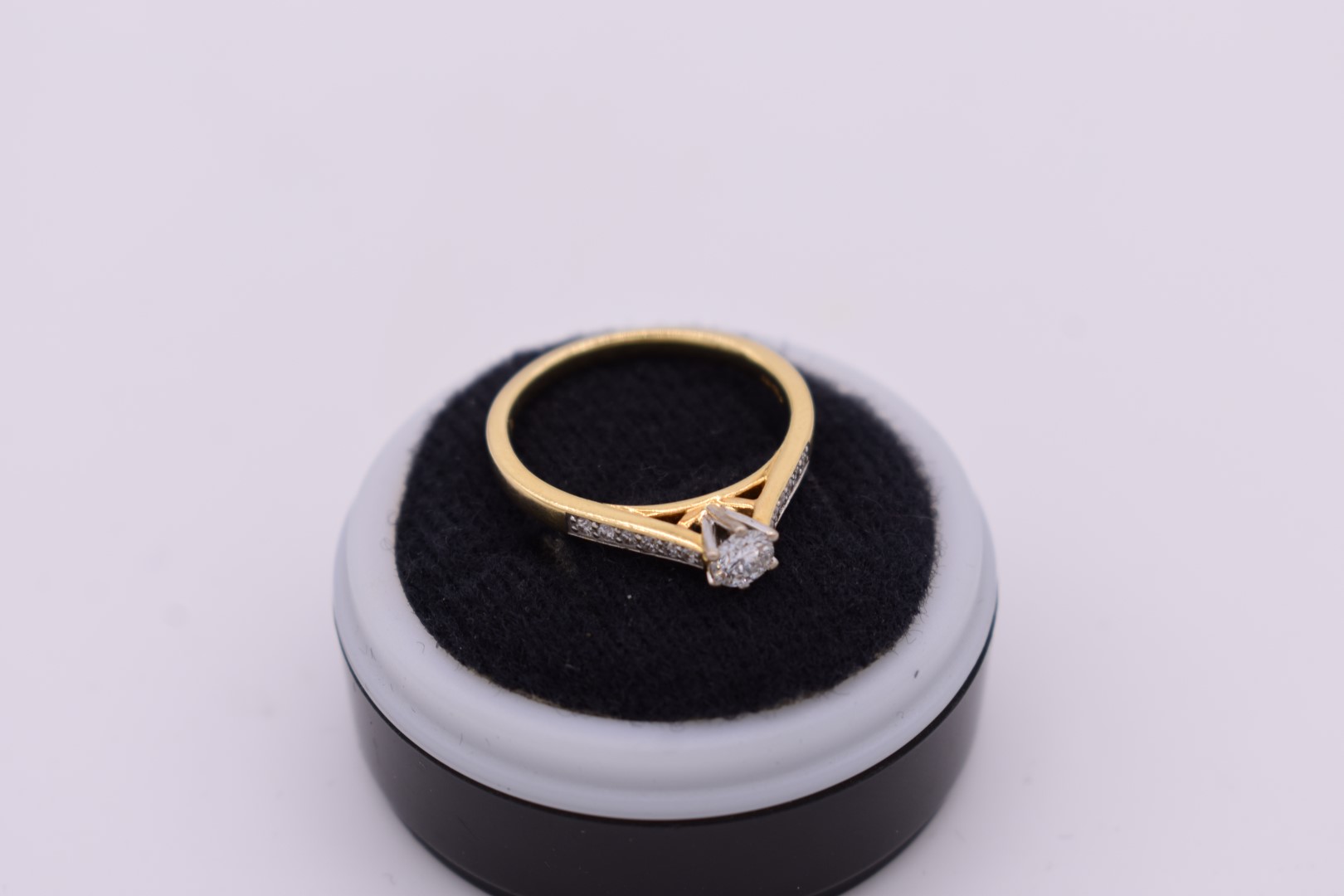 A diamond solitaire gold ring, hallmarked 750, having diamond chip shoulders, 3g. - Image 2 of 2