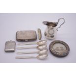 A small parcel of silver items, to include: a cream jug; a circular frame; four teaspoons etc,