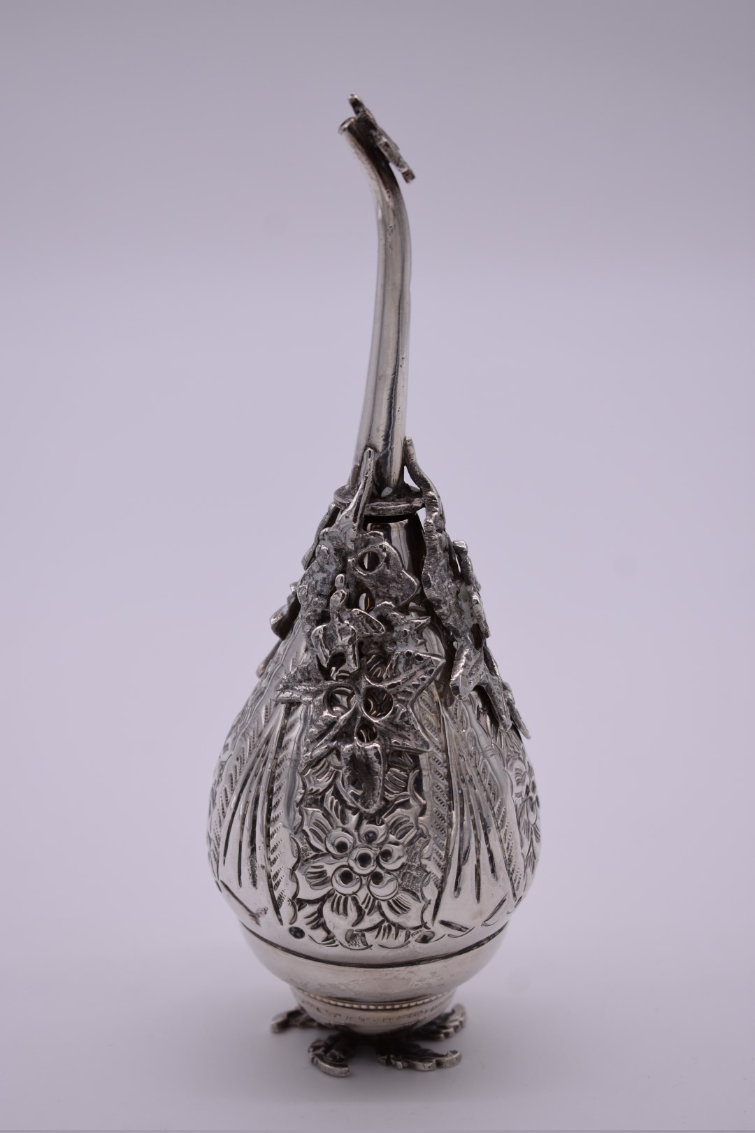 A Persian white metal rose water dropper, highly decorated birds and foliage, 19cm.