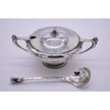 An Arts & Crafts hammered white metal sauce tureen and ladle, having rabbit and pheasant finials,