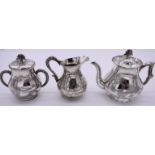 A Chinese white metal composite three piece teaset, stamped Chinese characters, decorated dragons