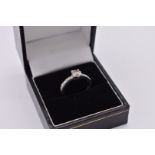 A diamond solitaire platinum ring, hallmarked 950, having diamond chip shoulders, the stone approx