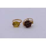 An oval yellow topaz dress ring; together with a floral garnet example, both unmarked.