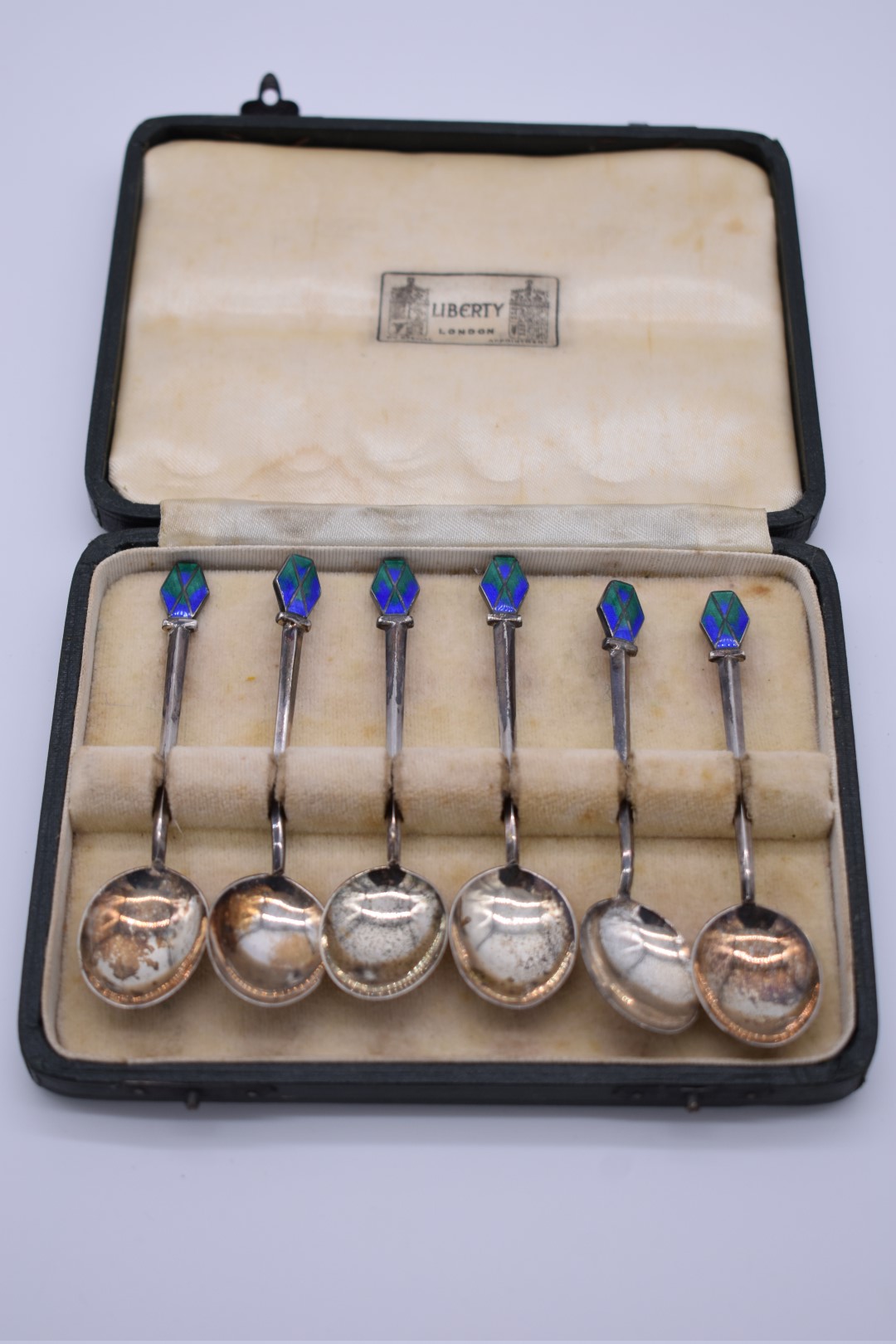 A cased set of six silver and enamel coffee spoons, by Liberty & Co, Birmingham 1934, 54g all in.