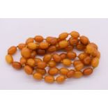 * WITHDRAWN FROM SALE* A string of butterscotch amber beads, 117cm long, 80g.