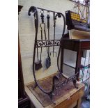 A wrought iron log and fire iron stand, 37cm wide.