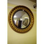 An antique gilt framed circular convex wall mirror, 67cm diameter.