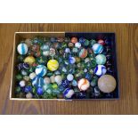 A collection of old glass marbles; together with a vintage golf ball.