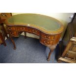 A late Victorian mahogany kidney shaped writing desk, with tooled green leather inset surface, on