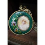 A brass and champleve enamel framed portrait miniature, indistinctly signed, with easel back, the