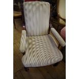 A Victorian walnut and upholstered open arm occasional chair.