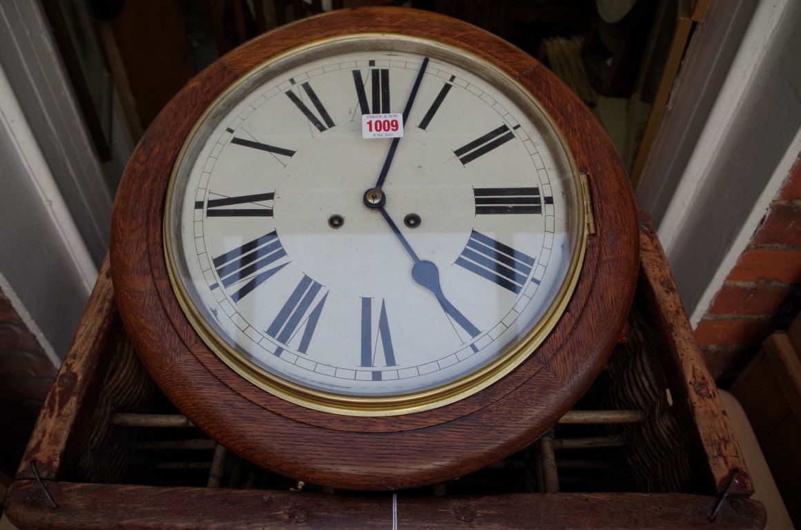 An oak circular wall clock, with 12in painted dial, with pendulum and winding key.