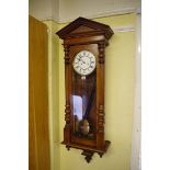 A walnut Vienna style wall clock, with enamel dial, 118cm high, with pendulum and weights.