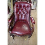 A Victorian mahogany and buttoned red leather open arm occasional chair, on brass caps and castors.