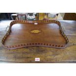 An Edwardian mahogany and inlaid twin handled gallery tray, of shaped outline, 57.5cm wide.