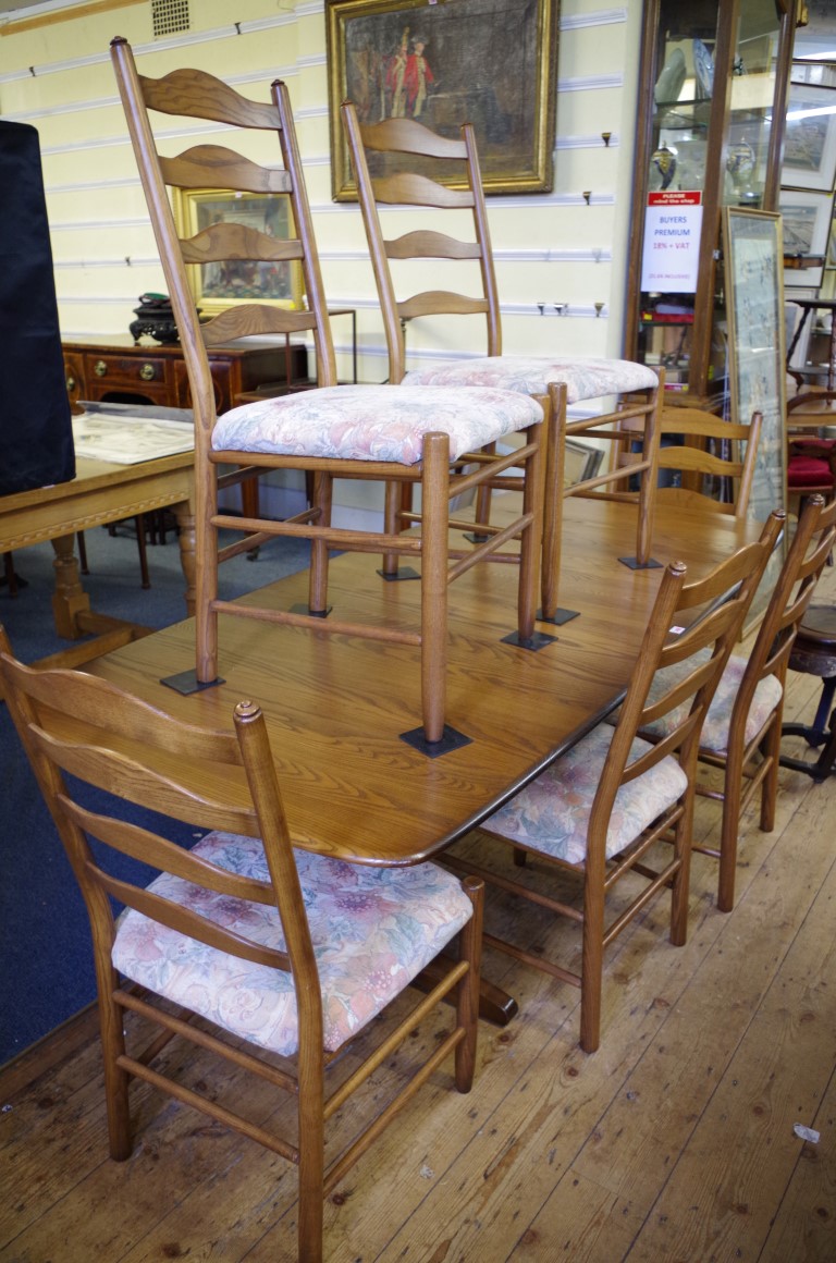 An Ercol 'Golden Dawn' dining table and chairs, comprising a drawleaf table, 203cm extended; and