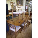 An Ercol 'Golden Dawn' dining table and chairs, comprising a drawleaf table, 203cm extended; and