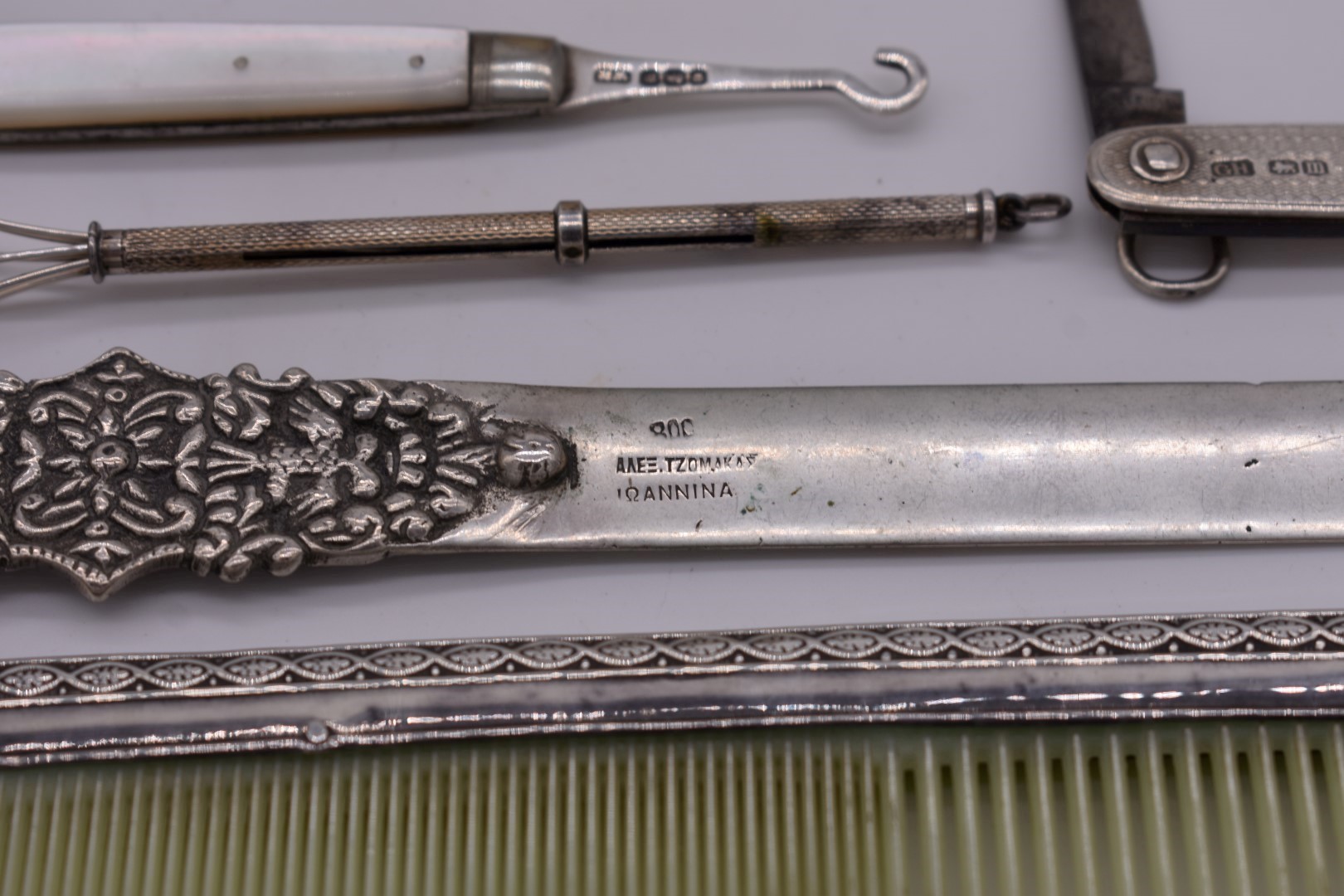 A sterling silver swizzle stick; together with a .800 letter opener; a silver mounted comb; and - Image 2 of 4