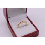 An unmarked yellow metal diamond half eternity ring.