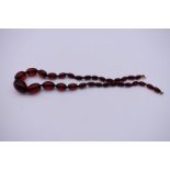 A graduated string of cherry amber beads, 57.5cm, 50.9g.