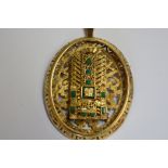 A yellow metal oval pendant, decorated Aztec sun god, set 10 malachites, stamped 18kt,