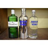 Two 1 litre bottles of Absolut vodka, one in tube; together with a 1 litre bottle of Gordon's