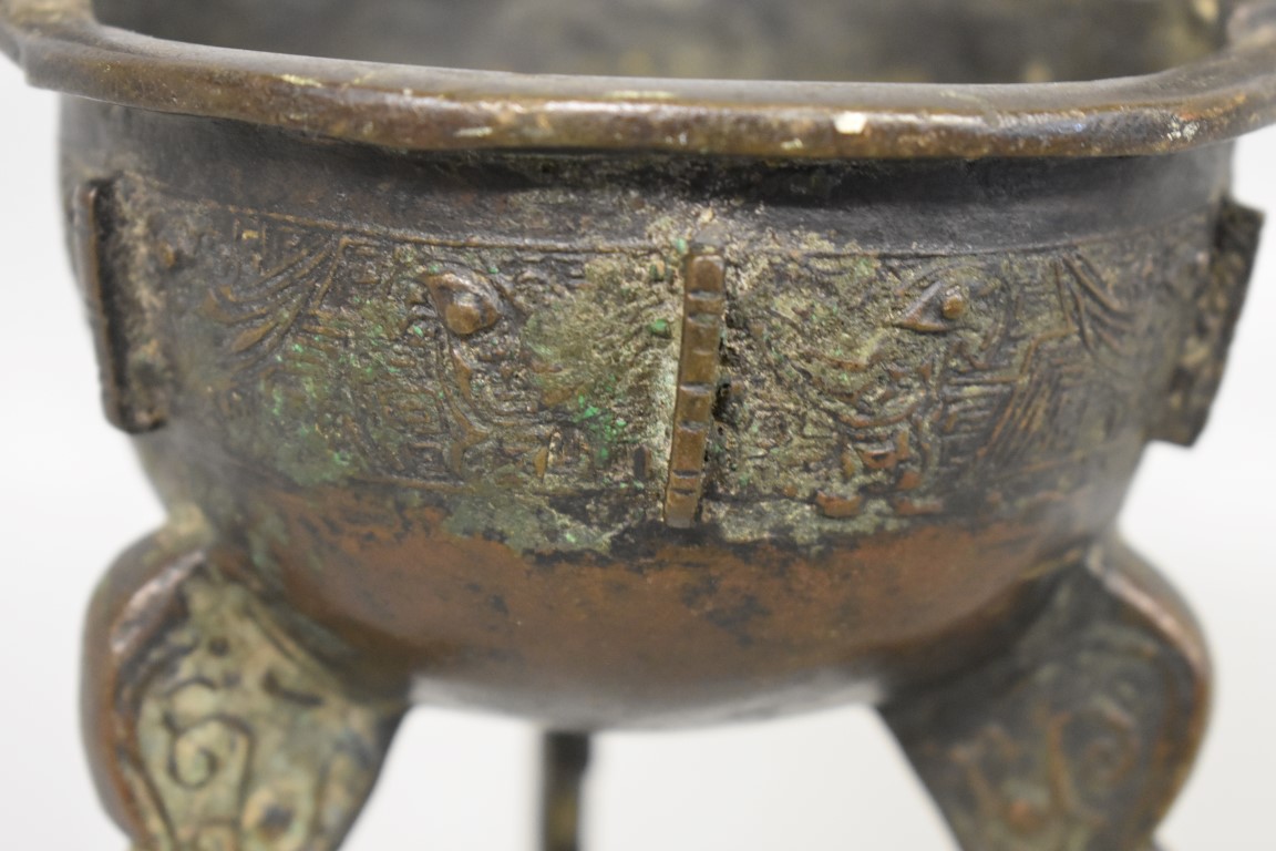 WITHDRAWN FROM SALE A Chinese Archiastic bronze twin handled tripod ding, with stylized decoration. - Image 2 of 6